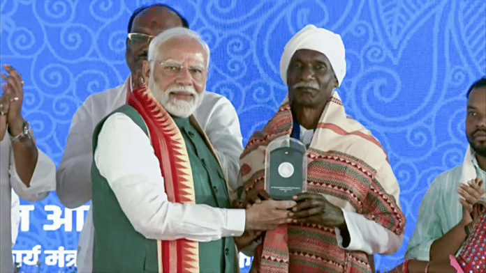 PM Narendra Modi presents a memento to Birsa Munda's descendant Budhram during the Janjatiya Gaurav Divas programme in Jamui on Friday | ANI
