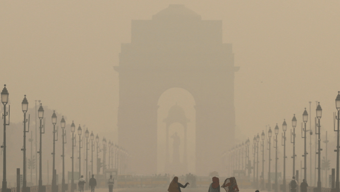 Women walk on a road near India Gate as the sky is enveloped with smog after Delhi's air quality worsened due to air pollution, in New Delhi, India, 19 November 2024. | Anushree Fadnavis | Reuters