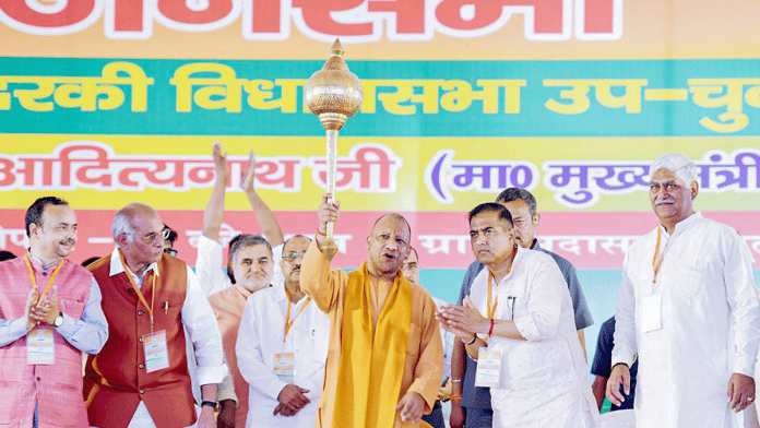 File photo of Uttar Pradesh CM Yogi Adityanath (with a mace in hand) canvassing for BJP candidate Ramveer Singh (standing with folded hands, right of Yogi) in Kundarki | ANI