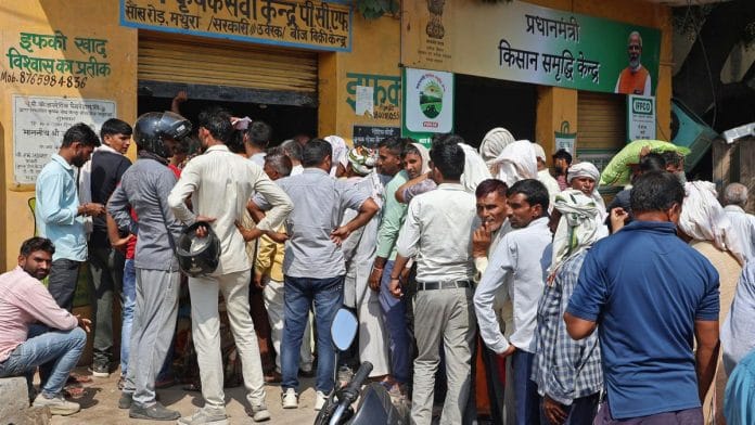 Farmers stand in a queue to purchase fertiliser at P.C.F Krishak Seva Kendra in Mathura on 18 October. | ANI