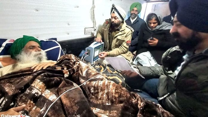 Police officials meet farmer leader Jagjit Singh Dallewal at the Khanauri border near Patiala Friday. | ANI