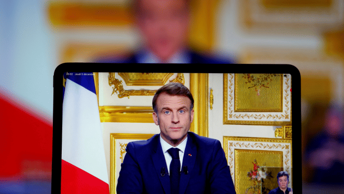 French President Emmanuel Macron appears on screen as he makes a television address to the nation after Prime Minister Michel Barnier's government was toppled in a no confidence vote in parliament, in Paris, France, on 5 December 2024. | Christian Hartmann | Reuters