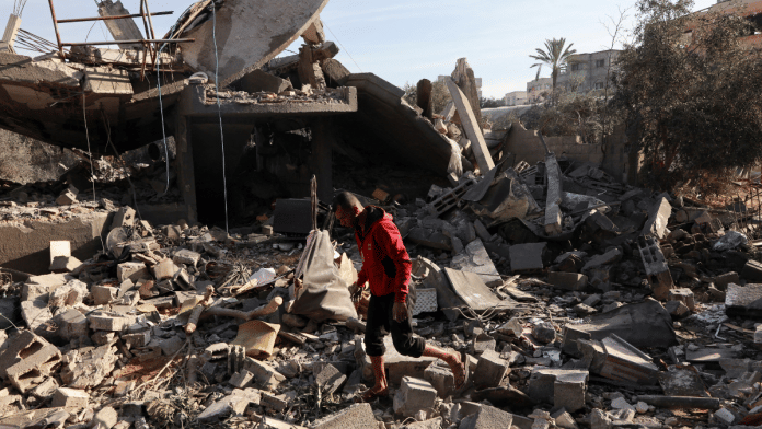 A Palestinian man inspects the site of an Israeli strike on a house, amid the ongoing conflict between Israel and Hamas, in Nuseirat, central Gaza Strip, on 11 December 2024. | Abd Elhkeem Khaled | Reuters