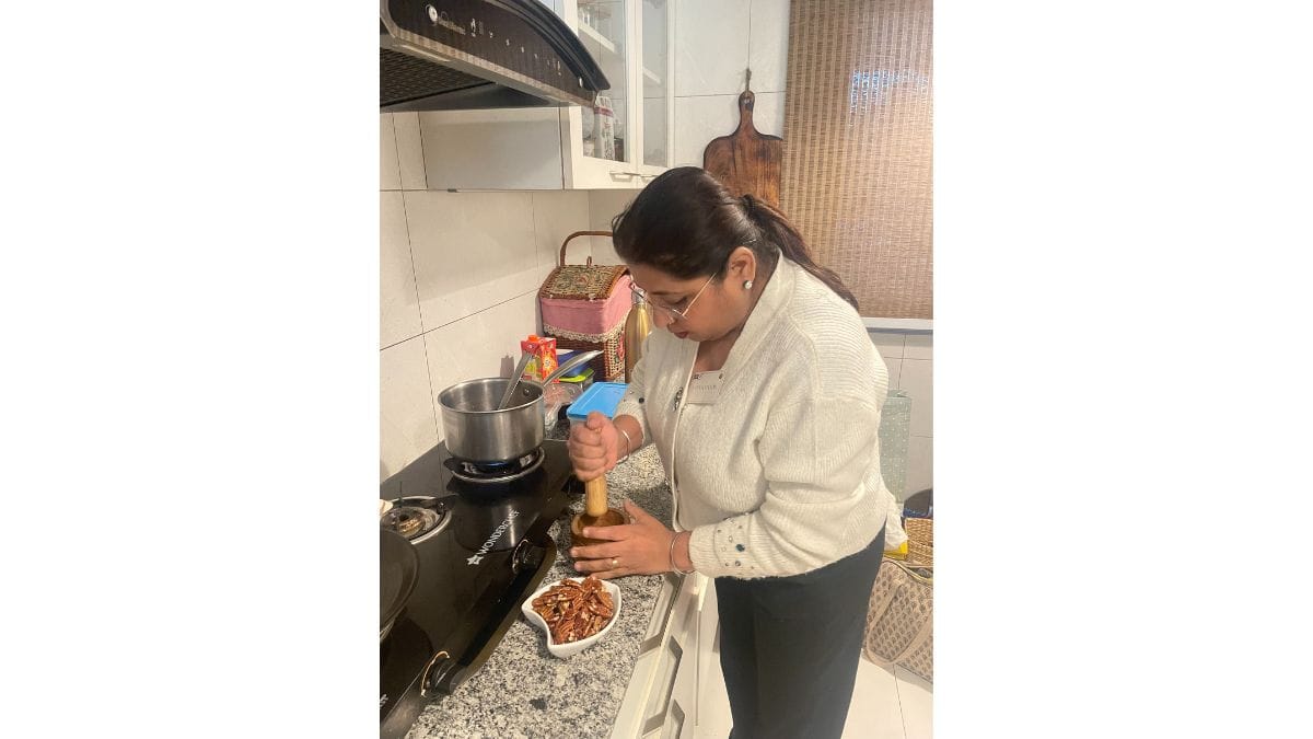 Home chef Lata Kapoor crushes roasted American pecan for her raab, a traditional winter drink crafted with maize flour | Triya Gulati, ThePrint