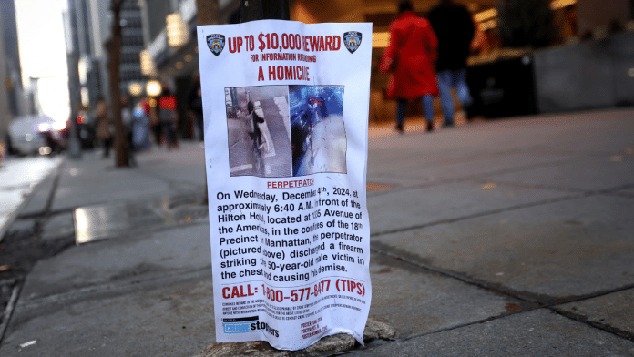 People walk next to a poster outside the Hilton hotel near the scene where the CEO of UnitedHealthcare Brian Thompson was shot dead in Midtown Manhattan, in New York City, U.S., on 5 December 2024. | Mike Segar | Reuters