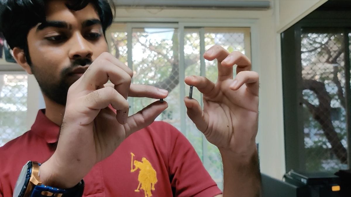 Menaria displaying two pieces of metal foam he has created under microgravity conditions in the drop tower