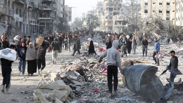 Displaced Palestinians walk past rubble to return to their homes, in the northern Gaza Strip, after Gaza ceasefire comes into effect on 19 January 2025. REUTERS/Dawoud Abu Alkas