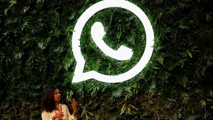 A woman stands next to a logo of messaging application Whatsapp during a Meta conference in Mumbai, India, September 20, 2023. REUTERS/Francis Mascarenhas