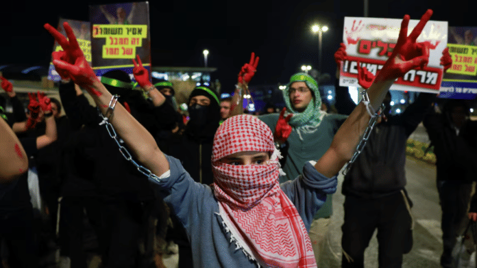 An Israeli youngster with red-stained hands protests a ceasefire deal that they see as an act of surrender, ahead of a ceasefire between Israel and Hamas, in Jerusalem, on 16 January 2025. | Ammar Awad | Reuters