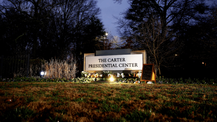 Flowers and mementos rest by the sign of The Carter Presidential Center, paying tribute to the former U.S. President Jimmy Carter | Representational Image | Reuters/Octavio Jones