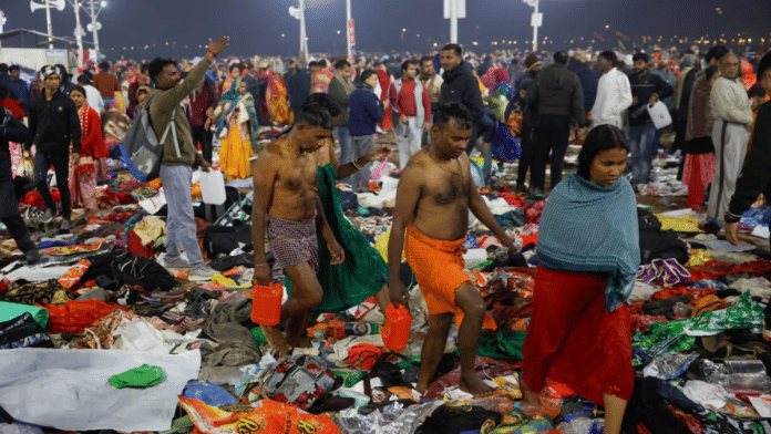 Devotees walk as they leave after a stampede before the second 