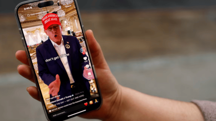 A woman poses with her smartphone displaying the @realdonaldtrump TikTok page, in Washington, U.S. on 19 January 2025. | Shannon Stapleton | Reuters