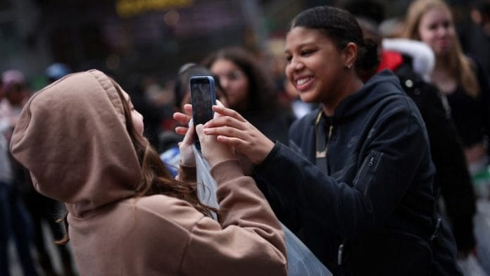 Representational Image | A young woman makes a video of her friends with a mobile phone to post on TikTok in Times Square in New York City, New York, U.S. | Reuters/Mike Segar