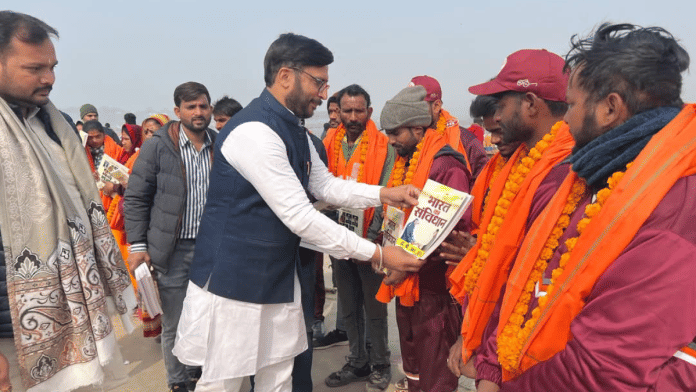 BJP state secretary Abhijat Mishra distributing Constitution booklets to sanitation workers at Maha Kumbh in Prayagraj | By Special Arrangement