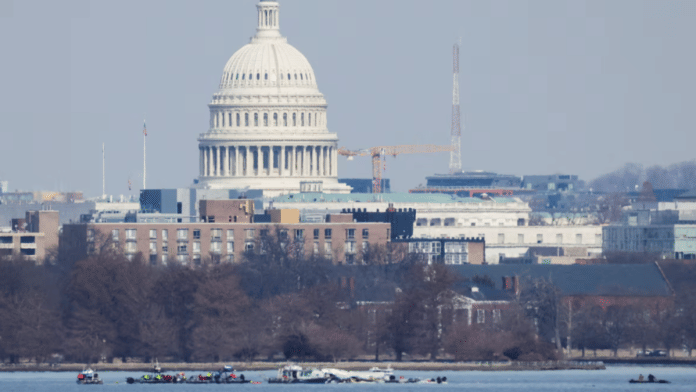Search and rescue teams work in the aftermath of the collision of American Eagle flight 5342 and a Black Hawk helicopter that crashed into the Potomac River, with the Capitol dome in the background, as seen from Virginia, U.S., on 30 January 2025. | Carlos Barria | Reuters