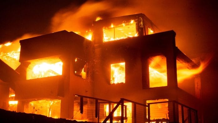Flames rise from a structure as the Palisades fire burns during a windstorm on the west side of Los Angeles, California Wednesday | Reuters