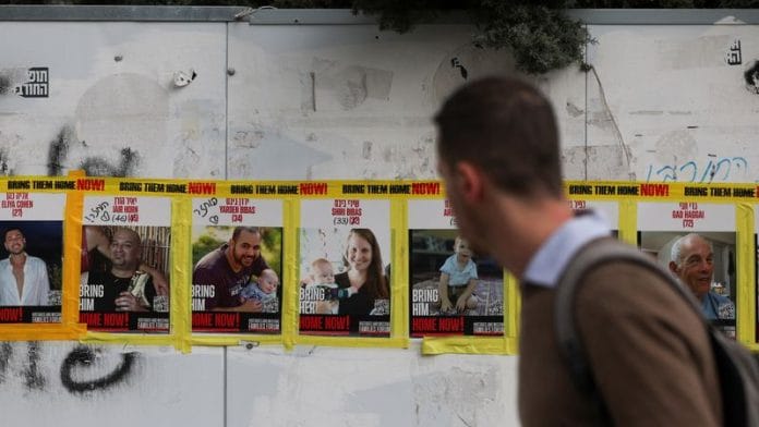 A man walks past pictures of Yarden Bibas, Shiri Bibas and Kfir Bibas, who were kidnapped during the deadly 7 October 2023 attack on Israel, in Jerusalem | Reuters/Ronen Zvulun/image captured 19 February 2025