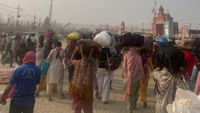Maha Kumbh attendees with their luggage after walking for hours | Photo: Udit Hinduja | ThePrint