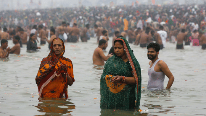 Two women pilgrims take a holy dip at the Sangam at Mahakumbh