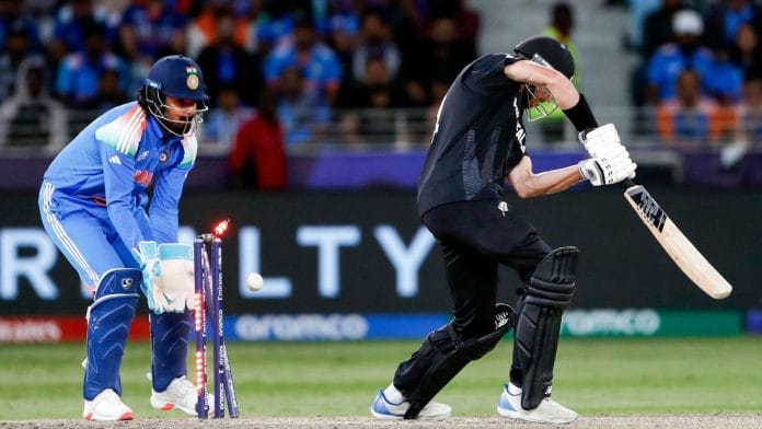 New Zealand's Mitchell Santner gets bowled by India's Varun Chakaravarthy during their ICC Champions Trophy 2025 Group A match at Dubai International Cricket Stadium on Sunday, 2 March | ANI