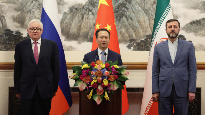 Russian Deputy Foreign Minister Sergei Ryabkov, Chinese Vice Foreign Minister Ma Zhaoxu and Iranian Deputy Foreign Minister Kazem Gharibabadi pose for a photo as they meet with reporters after their meeting at Diaoyutai State Guest House on March 14, 2025 in Beijing, China | Pool via Reuters/Lintao Zhang