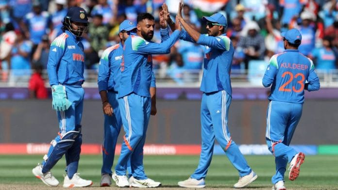 Spinner Varun Chakravarthy celebrates with teammates after taking the wicket of New Zealand’s Glenn Phillips during ICC Champions Trophy 2025 final match at Dubai International Cricket Stadium Sunday | Photo: REUTERS/ANI