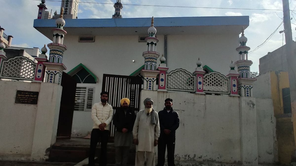 Moti Khan and Bhola Khan, as well Amandeep Singh who donated the land for the mosque, stand outside the newly made mosque in Bakhatgarh village of Barnala
