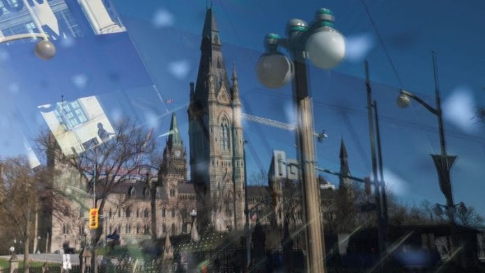 Parliament Hill is reflected on the window of a museum on the eve of a federal election, in Ottawa, Ontario, Canada on 27 April 2025. | Amber Bracken | Reuters