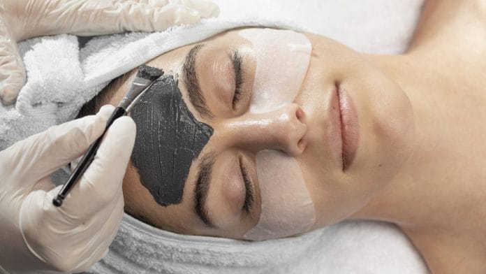 Dermatologist performing carbon laser treatment on patient’s face for glowing skin