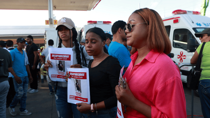 People hold pictures of a missing relative at the site of the collapsed Jet Set nightclub, in Santo Domingo, Dominican Republic April 9, 2025 | Reuters