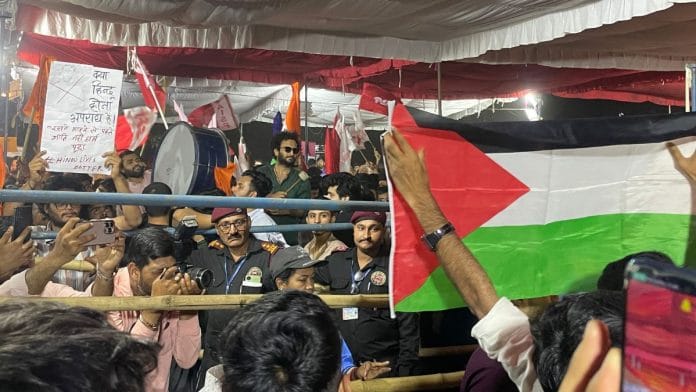 A Left-affiliated student group raises the Palestinian flag in front of an ABVP poster referencing the Pahalgam terror attack, during the JNUSU presidential debate | Photo by Kartikay Chaturvedi, ThePrint