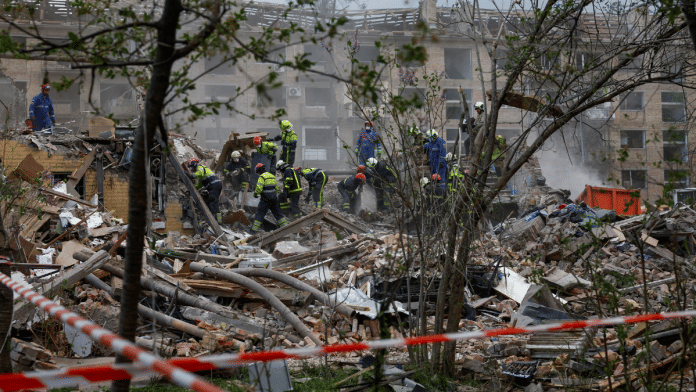 A rescuer with a service dog looks for residents, who could still be under rubber of a destroyed residential building, which was hit during a Russian missile strike, amid Russia's attack on Ukraine, in Kyiv, Ukraine April 24, 2025 | Reuters