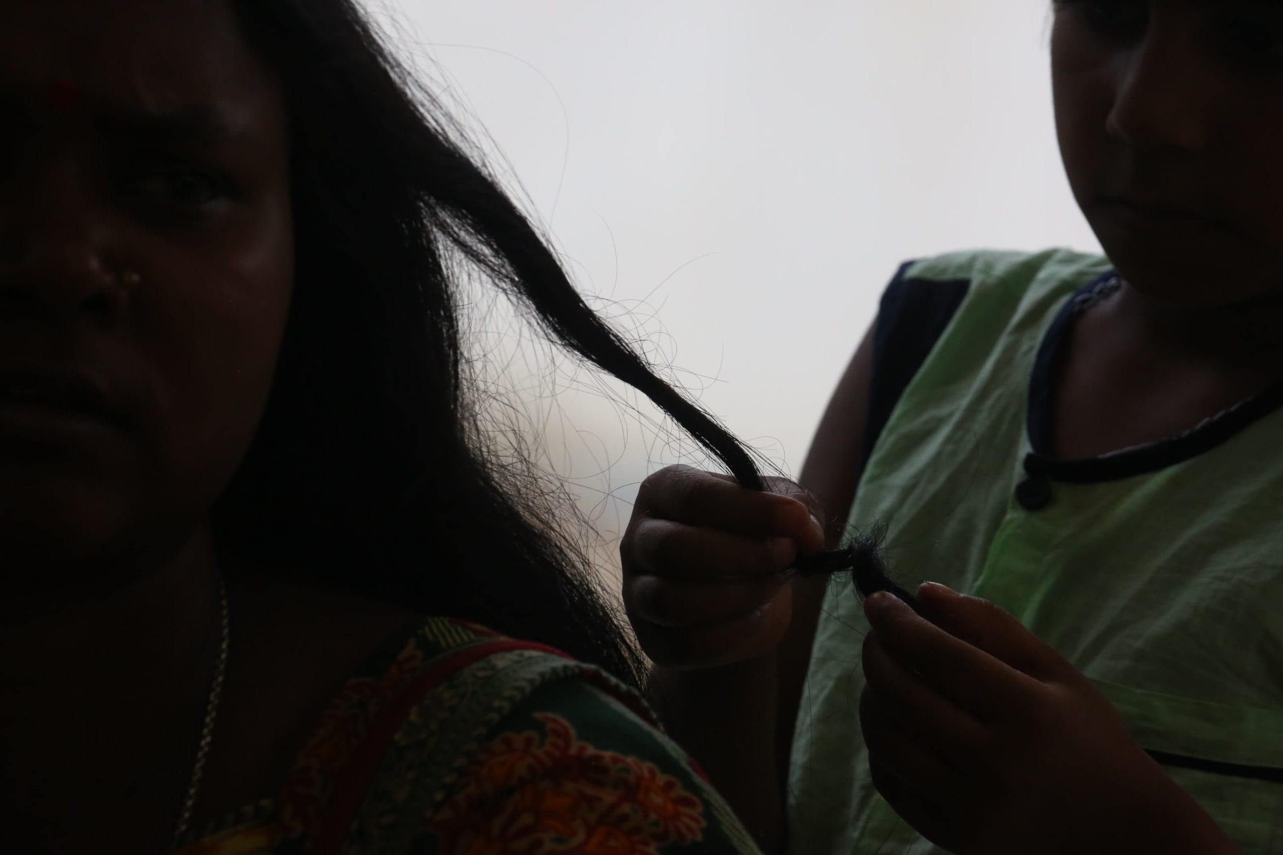 A daughter braids her mother’s hair at the relief camp in Malda | Praveen Jain | ThePrint