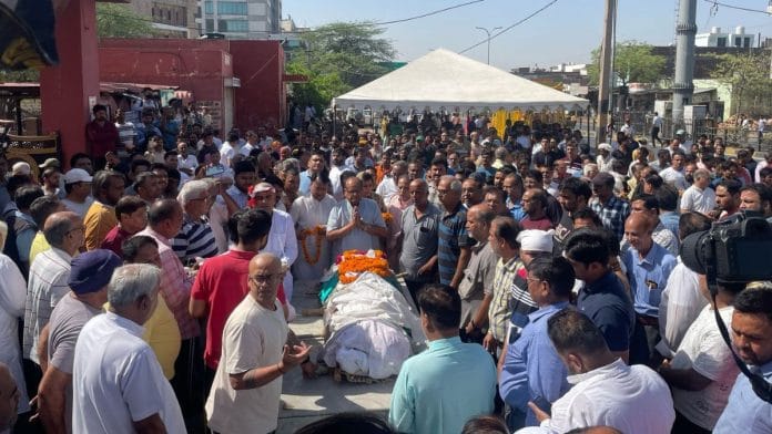Neeraj Udhwani’s body garlanded outside the crematorium gates | Photo: Udit Hinduja | ThePrint