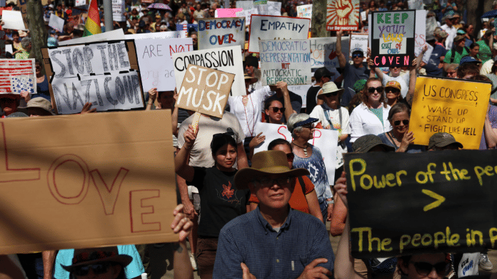 Demonstrators rally against U.S. President Donald Trump and his adviser Elon Musk during a 'Hands Off!' protest, in Asheville, North Carolina U.S., April 5, 2025 | Reuters