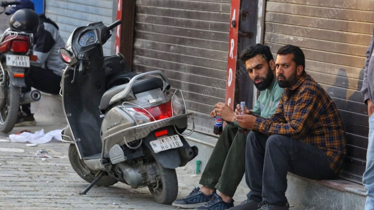 Shop owners sit outside downed shutters at Lal Chowk in Srinagar | Praveen Jain | ThePrint