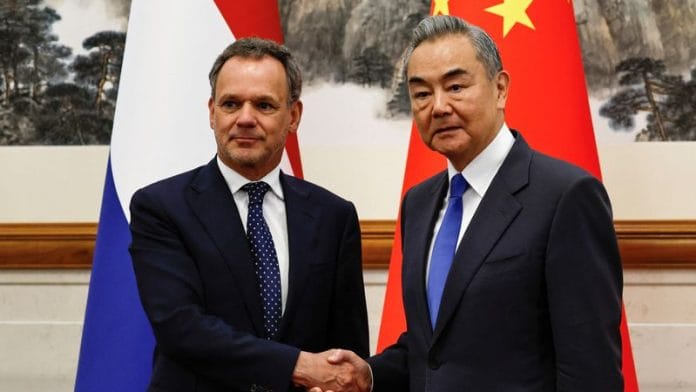 Chinese Foreign Minister Wang Yi and Dutch foreign minister Caspar Veldkamp shake hands as they pose for pictures before their meeting at the Diaoyutai State Guesthouse in Beijing, China on 22 May 2025. | Tingshu Wang | Reuters