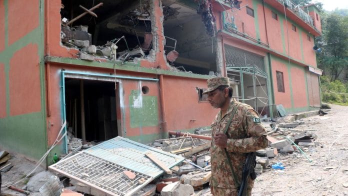 A Pakistan Army soldier stands in front of damaged Bilal Mosque after it was hit by an Indian strike in Muzaffarabad