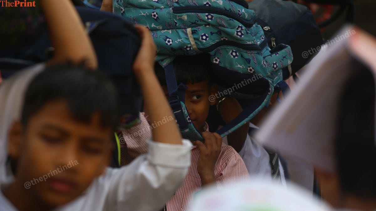 Students use their bags to cover their heads. | Manisha Mondal | ThePrint