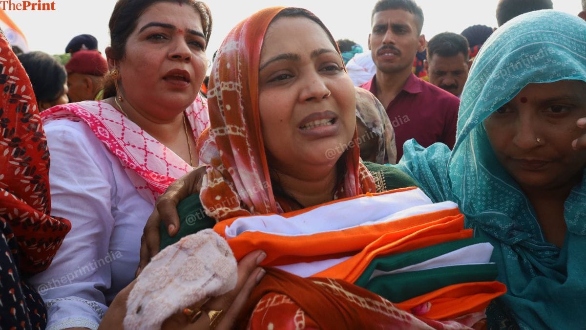 Dinesh's wife Seema Sharma holds the Indian flag that was wrapped around her husband's coffin | Manisha Mondal | ThePrint