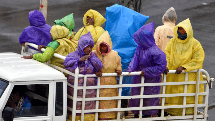 People travel via a mini truck during rain, near Chikkamagaluru, Karnataka, Sunday | PTI