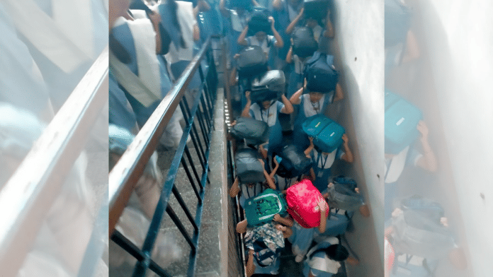 Students shield their heads as they take stairs to come out of a school building during the mock security drill | By Special Arrangement