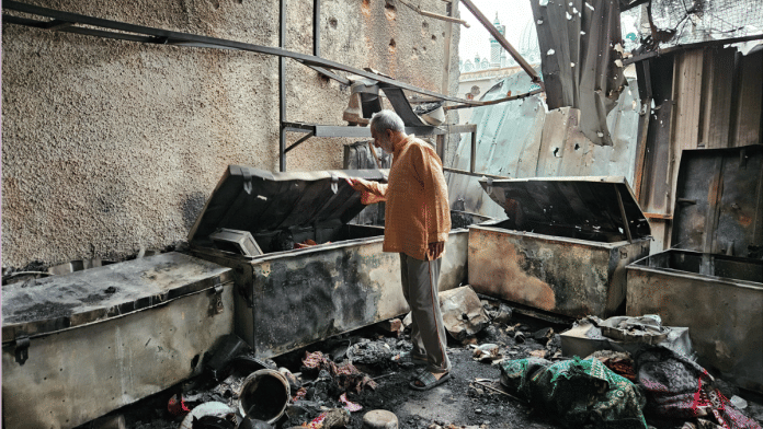 Mohammad Hafeez through the charred remains inside his house in Poonch | Sajid Ali | ThePrint