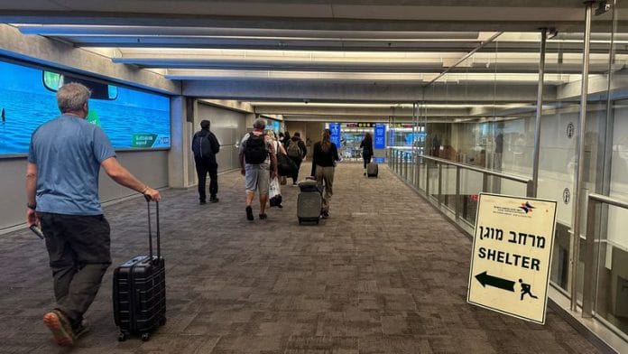 People walk next to a sign directing for Shelter after landing in Israel at the arrivals section of Ben Gurion International airport in Lod near Tel Aviv, Israel on 11 October 2023. | File Photo | Marius Bosch | Reuters