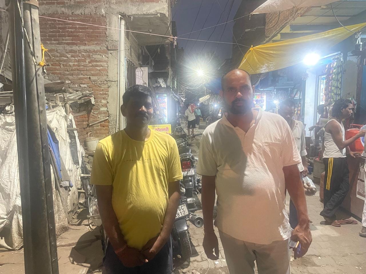 Housing is in short supply for daily wage labourers. Factory worker Dilip Kumar (left) and trade union president Gangeshwar Dutt Sharma (right) in front of informal housing units