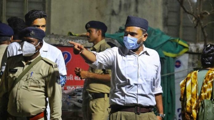 An RSS volunteer aiding in crowd control at Ahmedabad's B.Y. Medical College, where the bodies of the Air India crash victims have been kept | Praveen Jain | ThePrint
