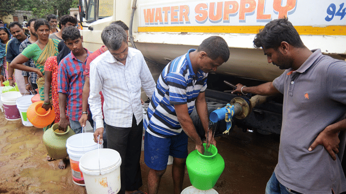 File photo of people standing in a queue to collect water from a tanker in Bengaluru | ANI