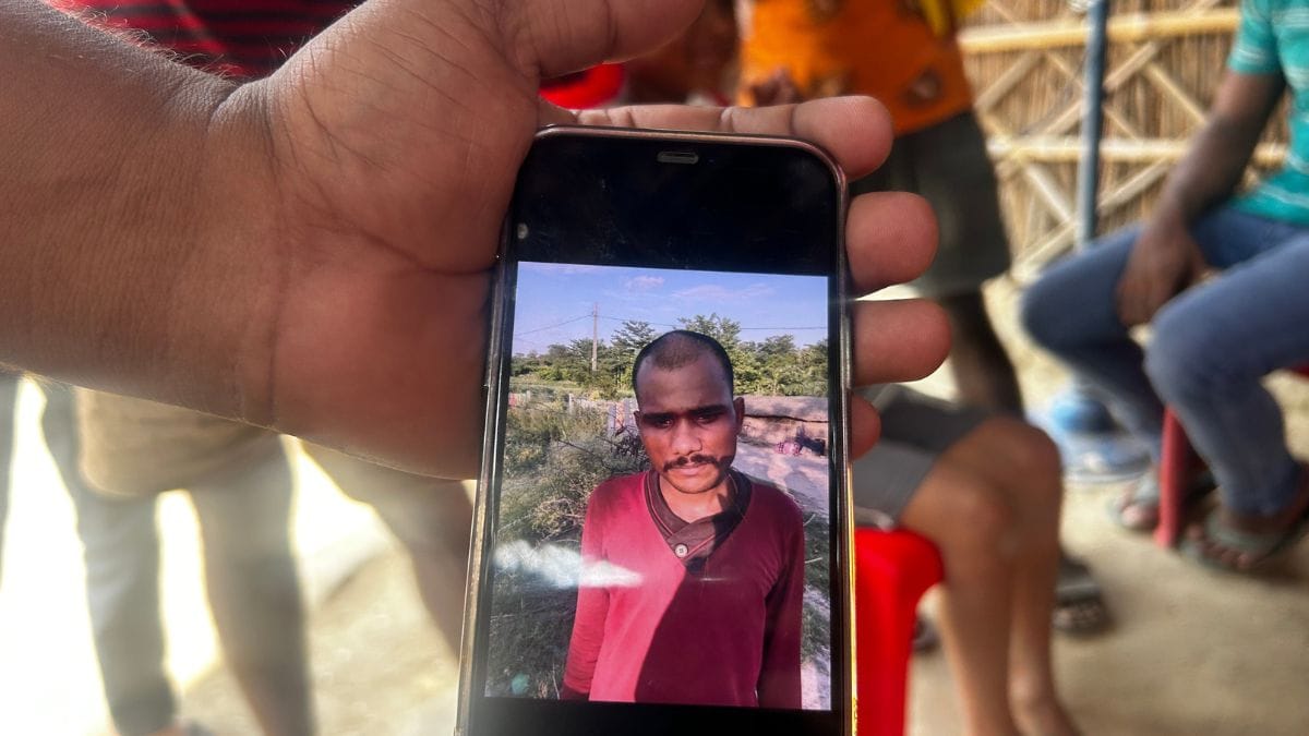 The grieving family holding up a photo of the accused. Allegedly, after leaving the child to die, he shaved his beard and visited the police station, reporting his lost mobile phone in Sonepur | Jyoti Yadav, ThePrint