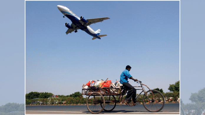 An IndiGo Airlines aircraft prepares to land as a man paddles his cycle rickshaw in Ahmedabad, India, October 26, 2015 | File photo | Reuters