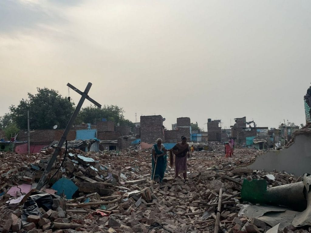 Residents walk through the rubble in Jailorwala Bagh after the slum demolition drive